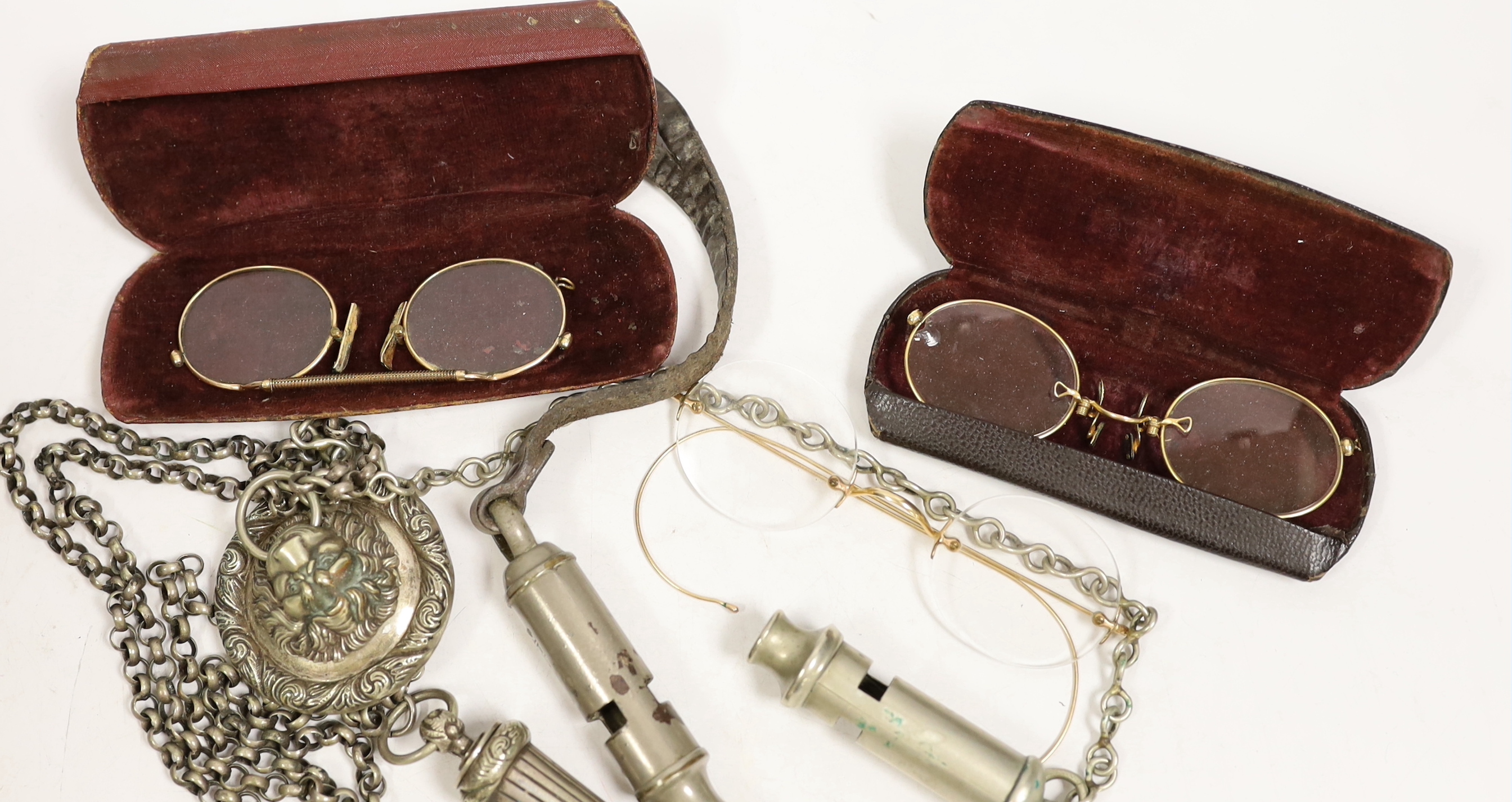 Three pairs of pince-nez and three police whistles